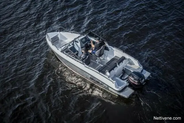Two people in a Falcon boat navigate on dark water, with visible dashboard controls and an outboard motor.